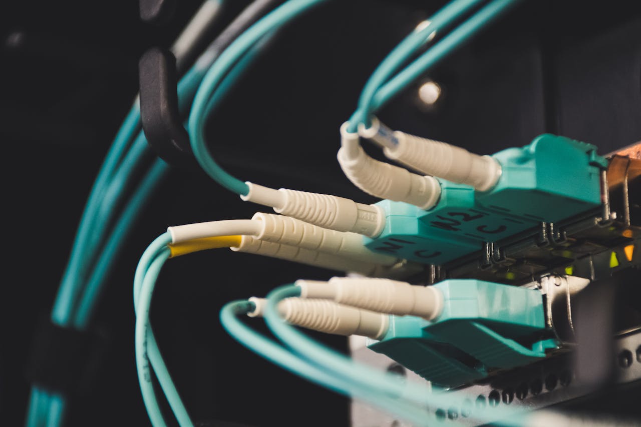 Detailed view of fiber optic cables and ports in a server room, showcasing connectivity.